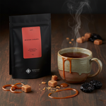 Pouch Chá Puerh Belgian Caramel Moncloa ao lado de caneca com chá quente e caramelo