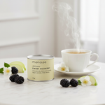 Mini lata Chá Branco Sweet Mulberry Moncloa ao lado de xícara com chá quente e amoras frescas