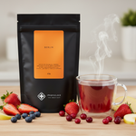 Pouch Chá Berlin Moncloa ao lado de xícara com chá quente de frutas vermelhas